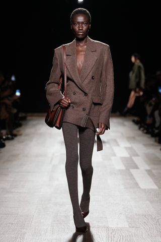 Ferragamo model wearing a brown oversize blazer with brown wool tights.