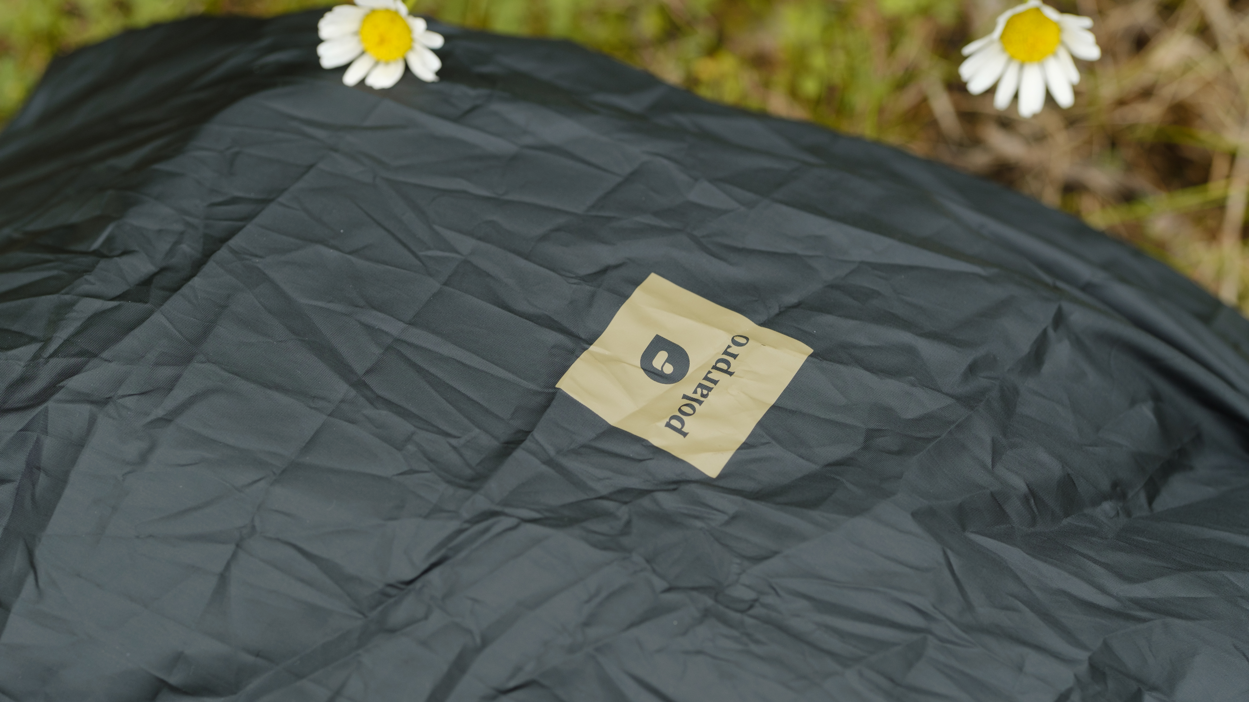 The PolarPro RoadRunner 16L camera backpack outside with wildflowers