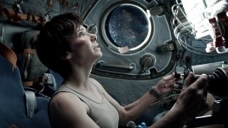 A concerned Ryan Stone sits in a space shuttle cockpit in Gravity