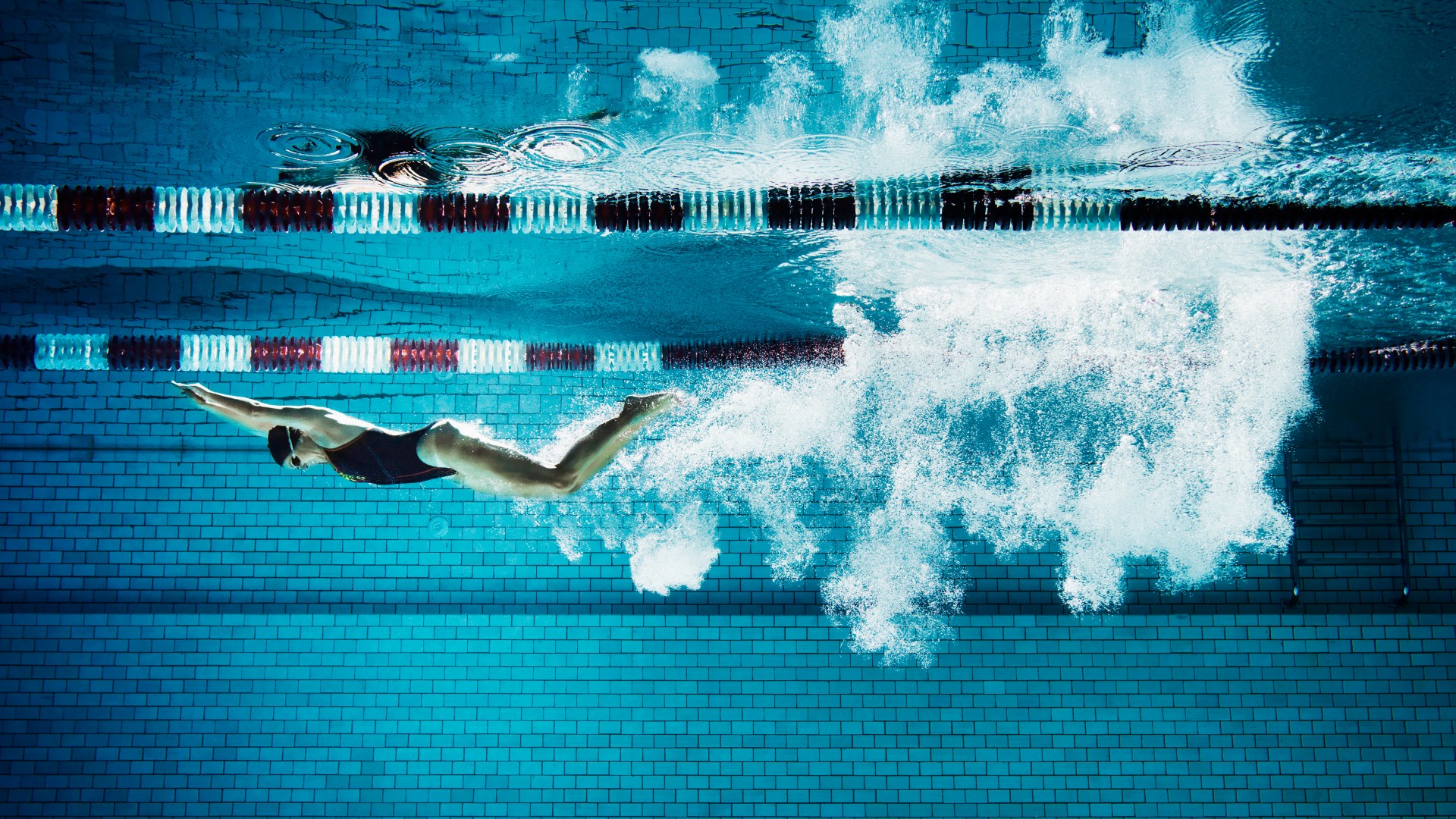 A woman under water in a swimming pool