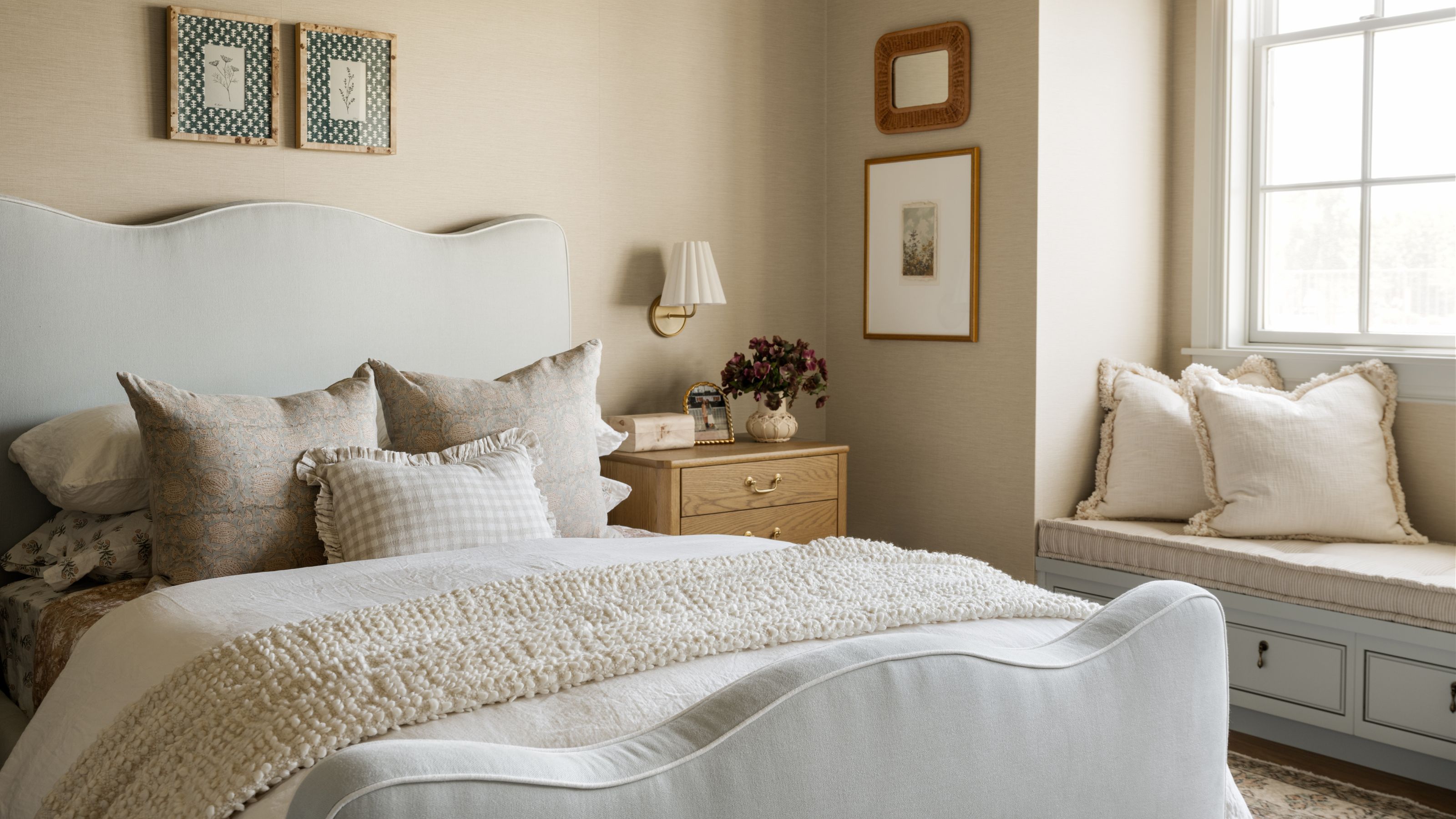 a kids bedroom with a scalloped light blue bed, floral linens and a sweet window seat