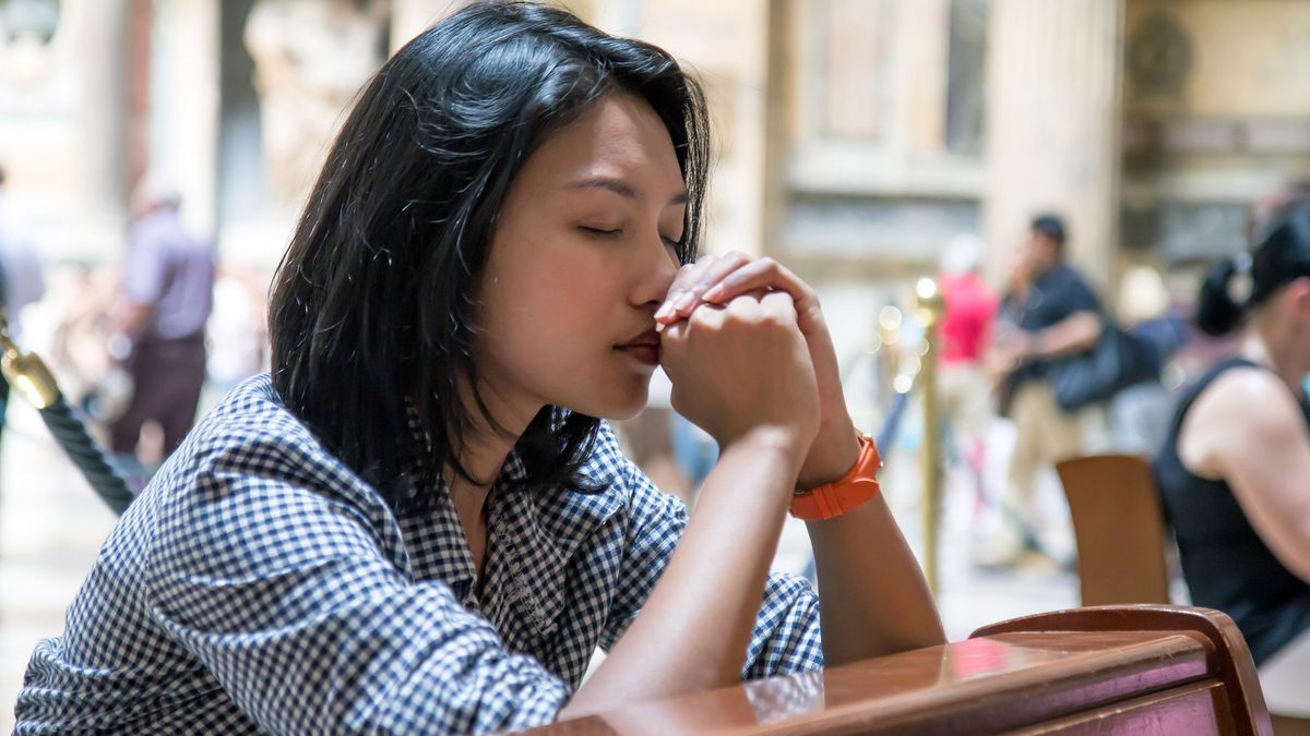 Woman praying in church.