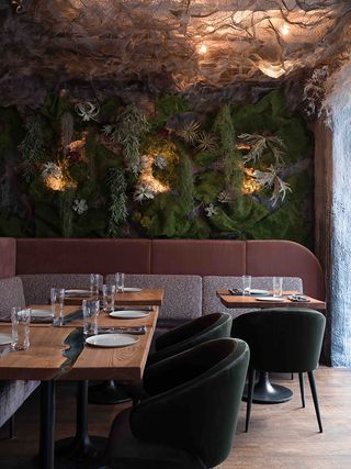Human restaurant, Moscow with green, grey, brown and brown seating and a living wall
