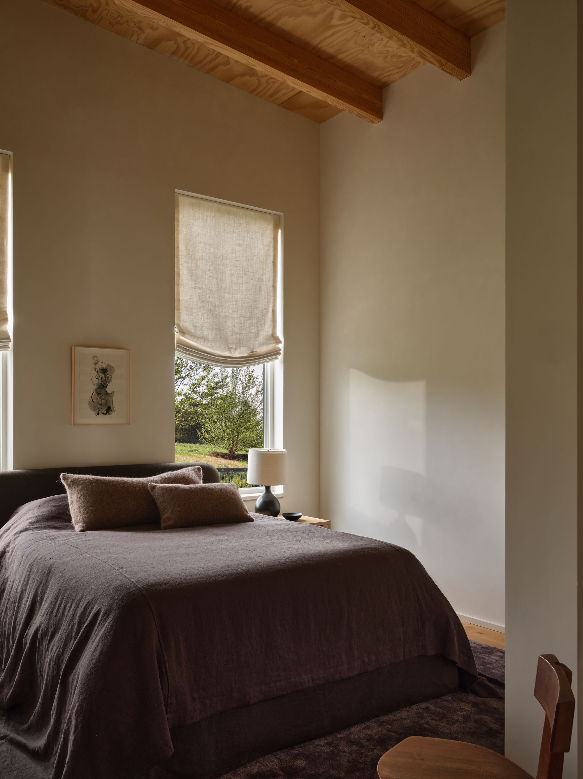 bedroom with a chocolate brown bed and tall white walls