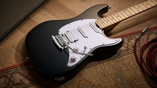 Sterling By Music Man Intro Series Cutlass: the entry-level double-cut electric is finished in gloss black, has a three-ply white pickguard and a maple fingerboard with black dot inlays.