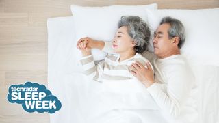 How much sleep do you need: An older couple sleep on their sides while cuddling in a white bed