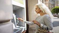 An older woman uses an ATM Machine.