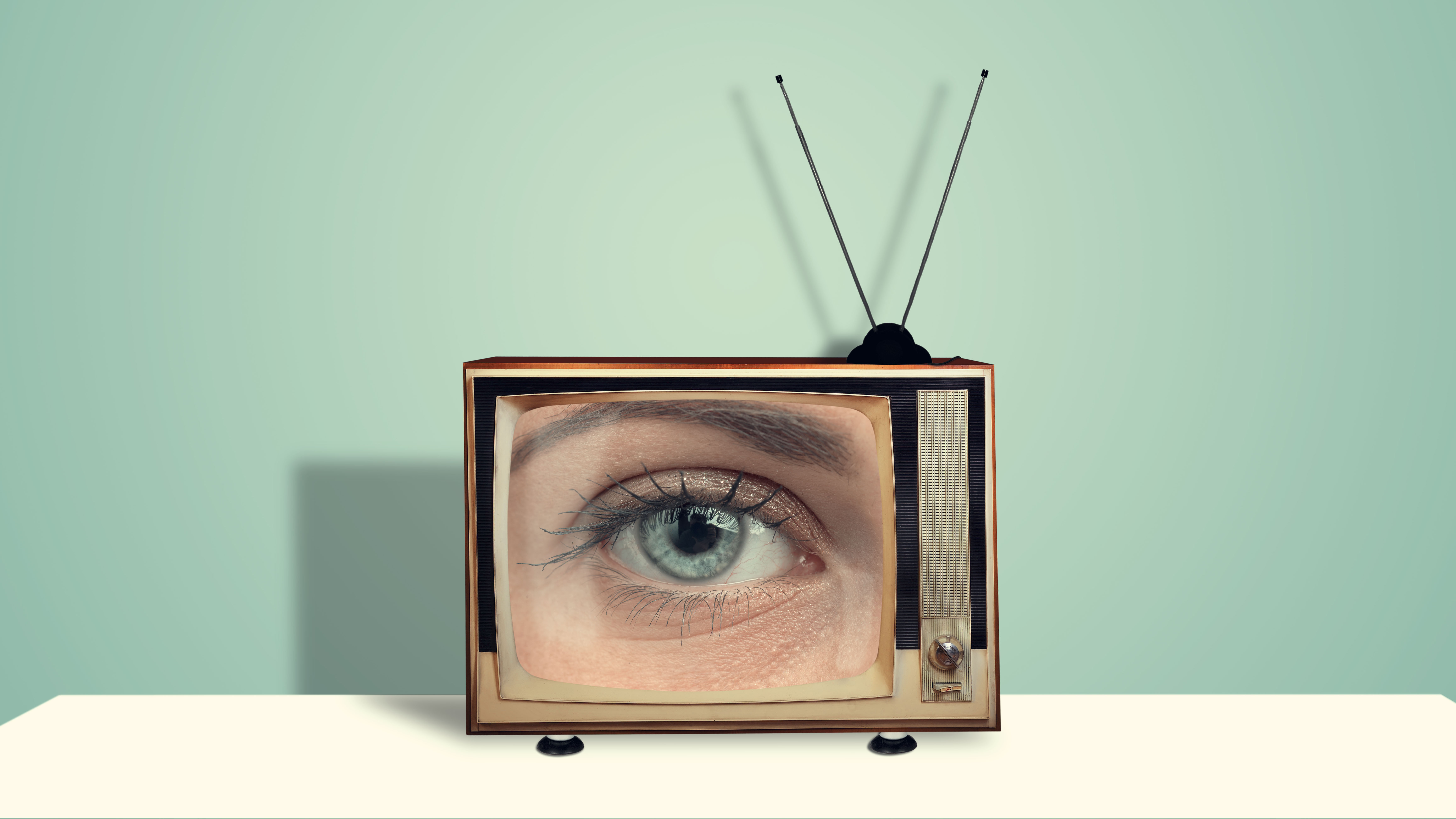 An old-style television with an eye looking out from it suggests surveillance on viewers.