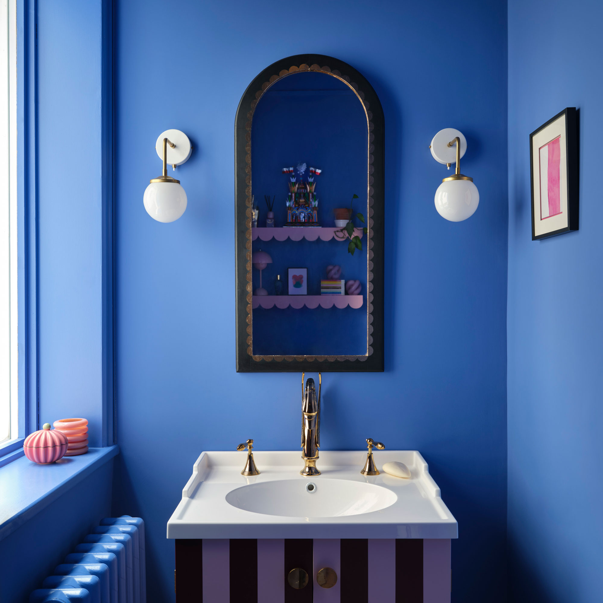 Bright blue wash room with striped vanity unit