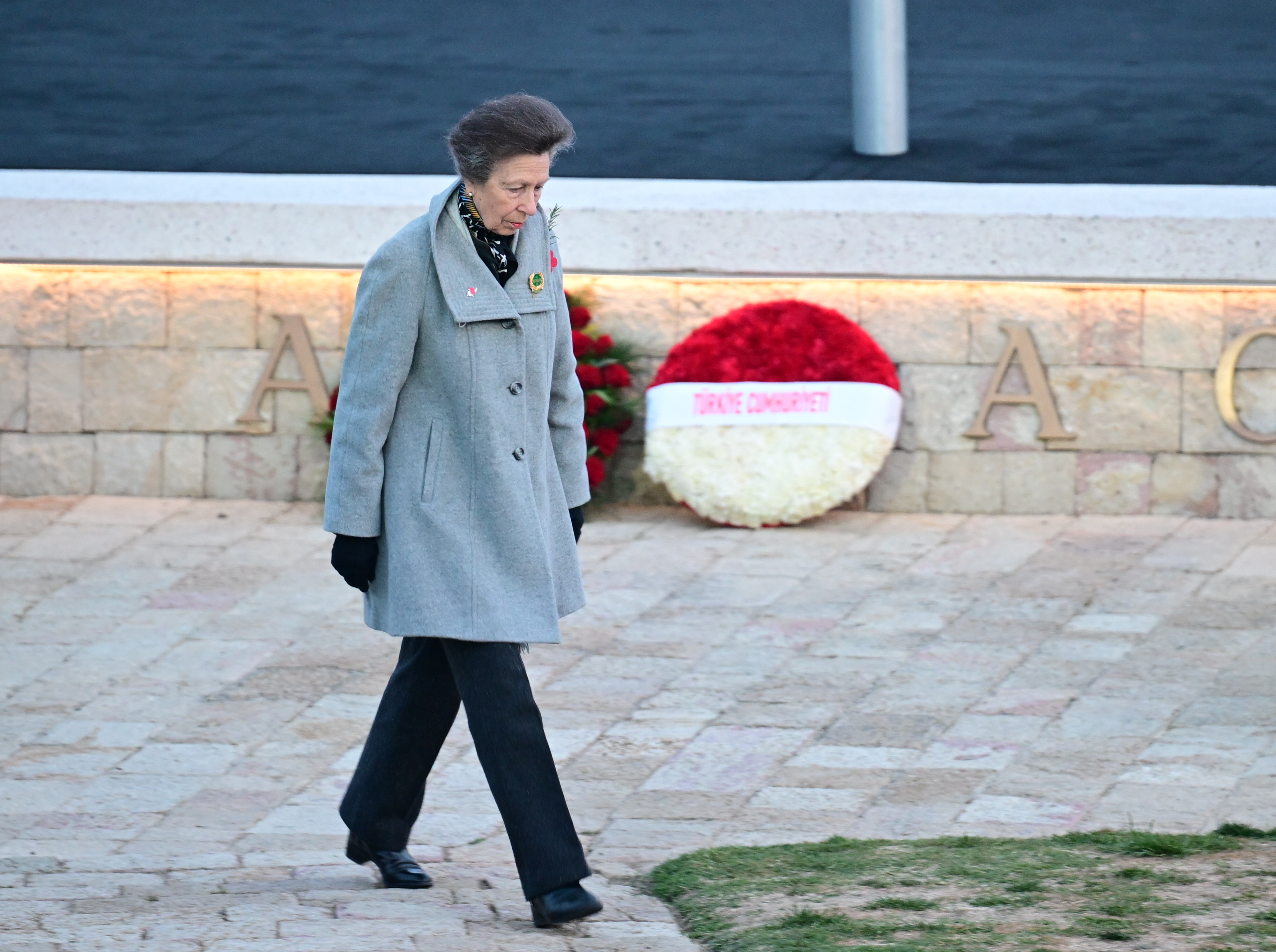 Princess Anne wearing a gray coat attends an Anzac Day service