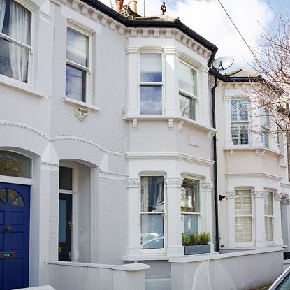 house exterior with white wall and white window and blue door