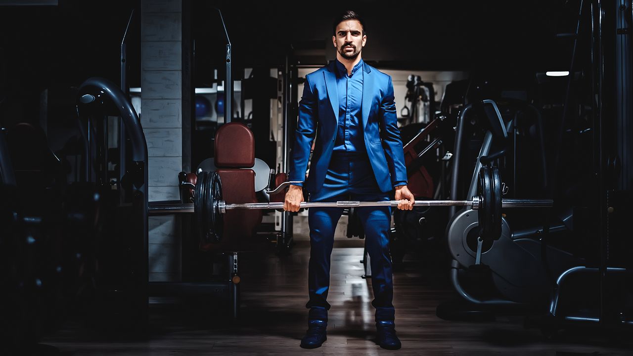 Man in suit lifting heavy weight