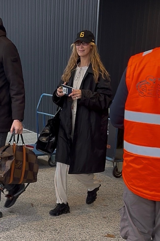 Bella Hadid arrived at Milan Fashion Week wearing her Nike Shox TL sneakers, a matching beige set, and an oversize Prada bag