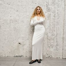 Model wearing a white maxi dress and black ballet flats sold at luisaviaroma