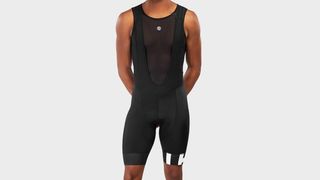 A man wearing black Siroko bib shorts with a black base layer against a white background