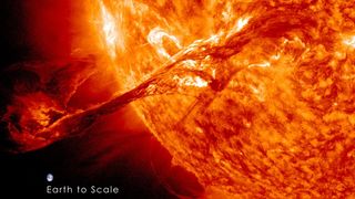 A fiery stream erupts from the sun. An inset of Earth for scale shows that the entire Earth is significantly smaller than the coronal mass ejection.