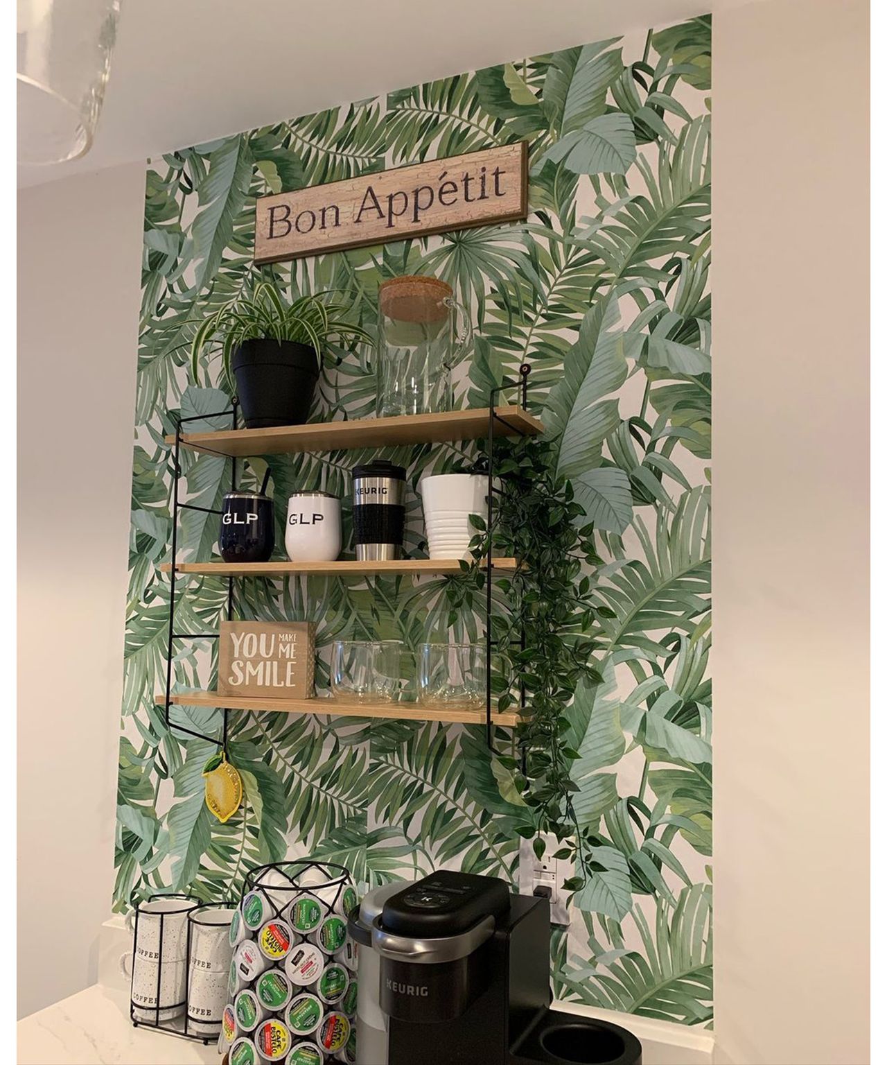 A DIY coffee bar with palm print peel-and-stick wallpaper, Macy's shelf and dangling faux plant from Ikea