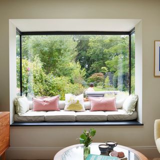 Window seat in picture window with views out to a lush garden