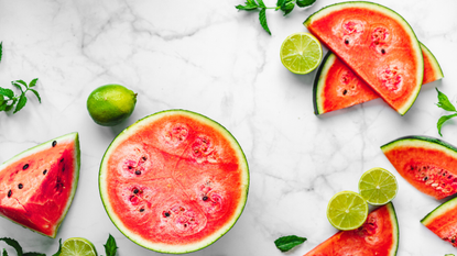 Watermelon and lime slices on a marble surface