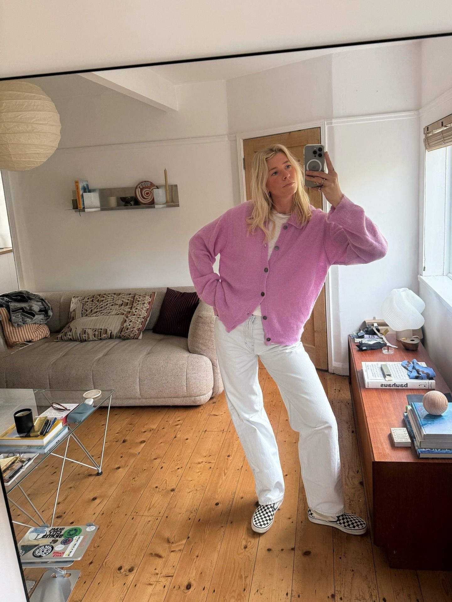 Fashion person Lindsey Holland wears the checkered vans slip on trainers trend. She wears a pink cardi and white jeans.