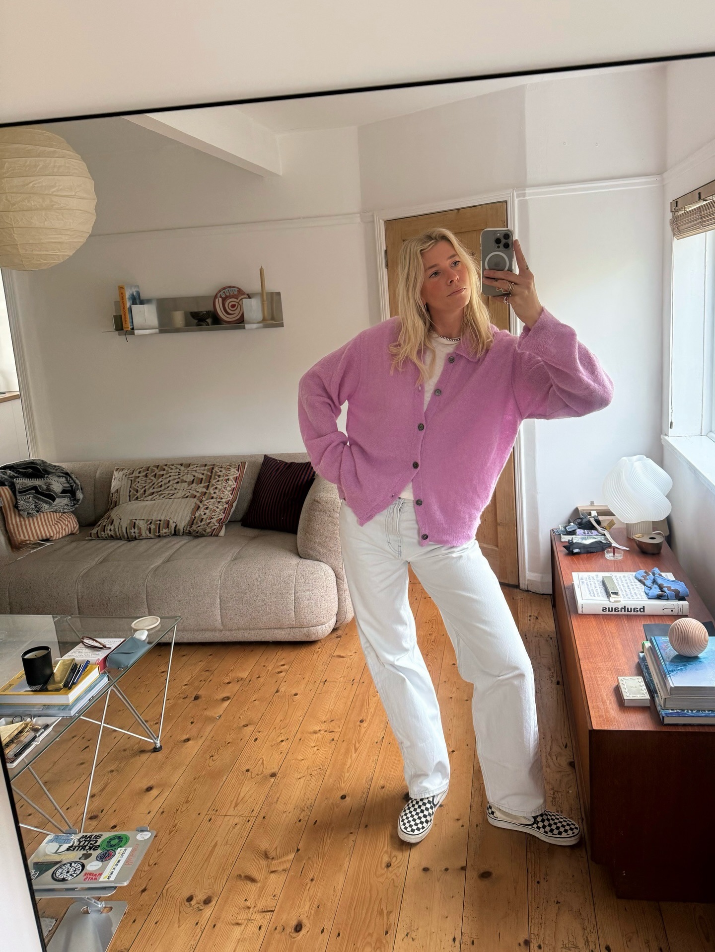 Fashion person Lindsey Holland wears the checkered vans slip on trainers trend. She wears a pink cardi and white jeans.