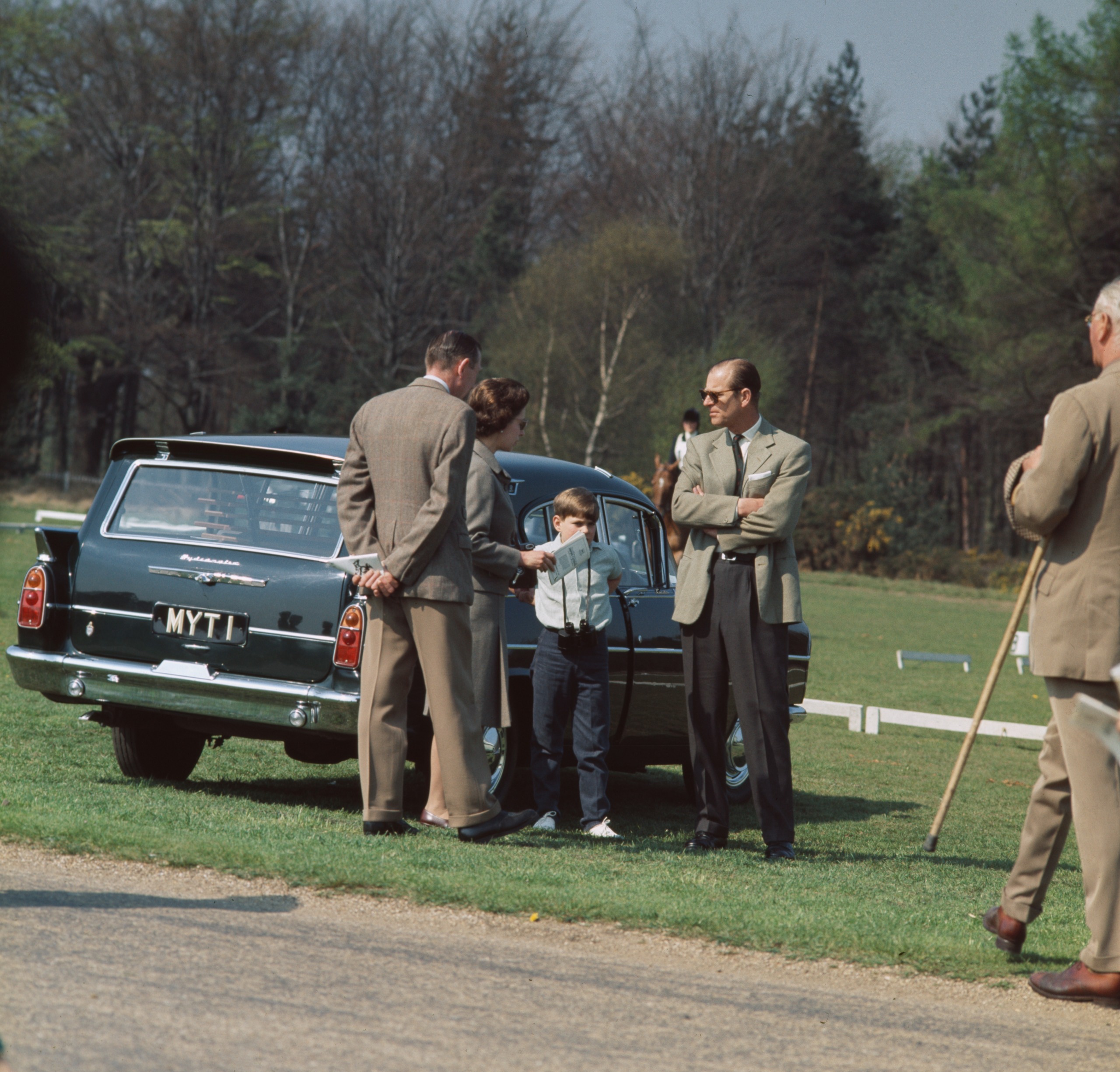 Prince Philip, Queen Elizabeth and Prince Andrew standing next to The Queen's car with a license plate stating &amp;quot;MYT1&amp;quot;