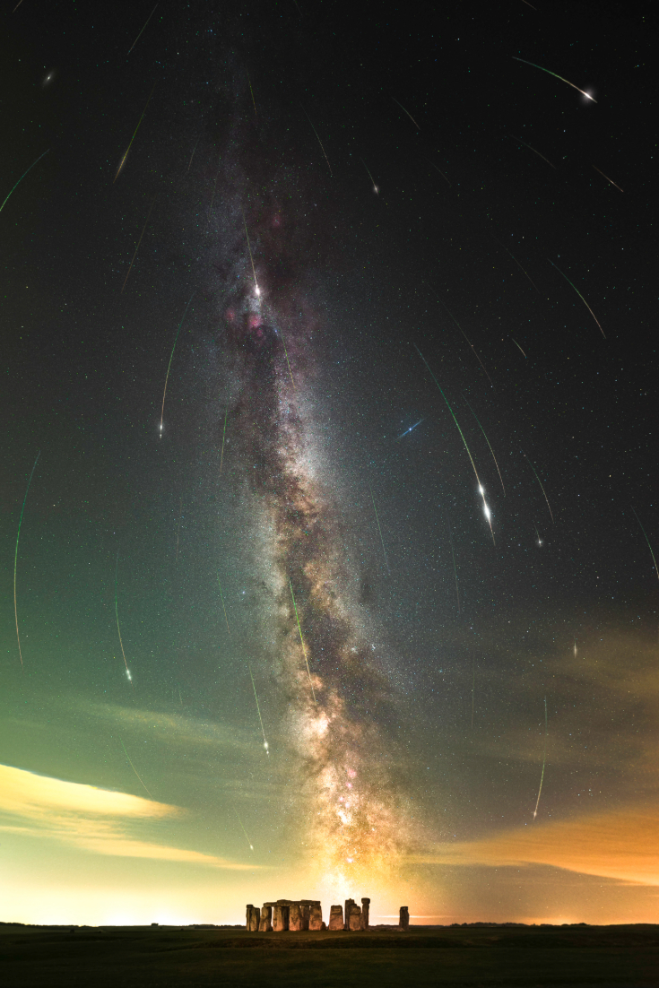The Milky Way glows brightly and shooting stars are seen over the sky over Stonehenge