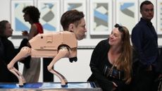 A visitor looks at a robot in the likeness of Elon Musk at artist Michael Winkelmann's Regular Animals installation at Art Basel in Miami Beach, Florida