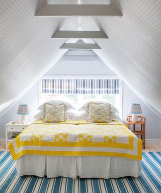 loft bedroom with wallpapered ceiling and striped rug