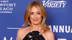 Picture of Cat Deeley smiling with curled long golden blonde hair and wearing a black and white polka dot halterneck dress