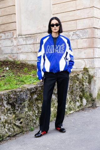 woman wearing black sneakers with a blue jacket.