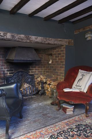 fireplace with brick surround and velvet and leather armchairs