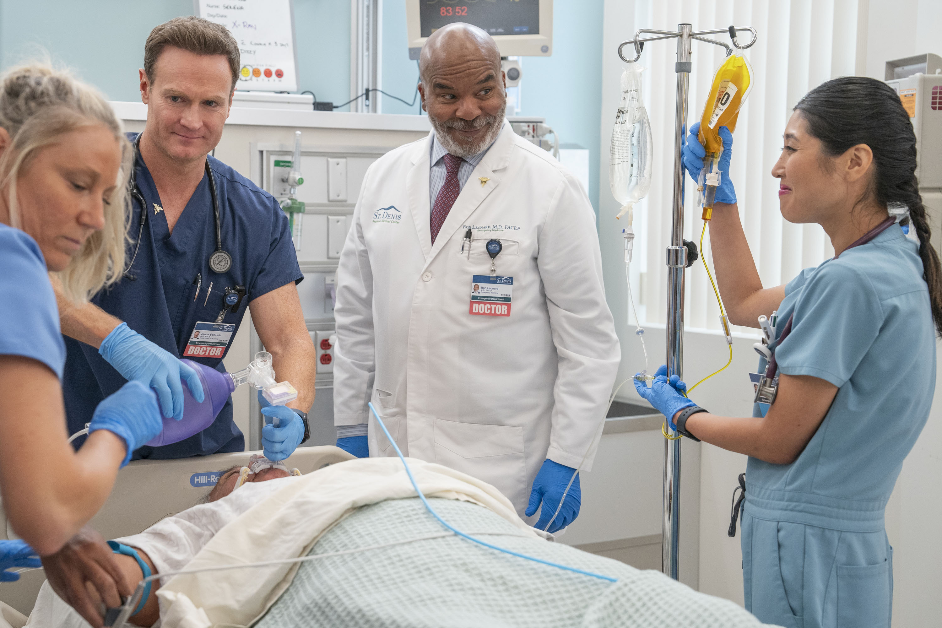 Josh Lawson, David Alan Grier and Kaliko Kauahi as their St. Denis characters, laughing while treating a patient in a hospital bed.