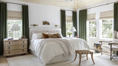 How to choose the right size area rug for your bedroom; Neutral bedroom with green curtains by Marie Flanigan Interiors 