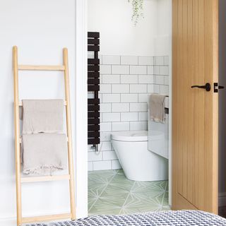 en suite bathroom with green floor tiles and white metro tiles on wall