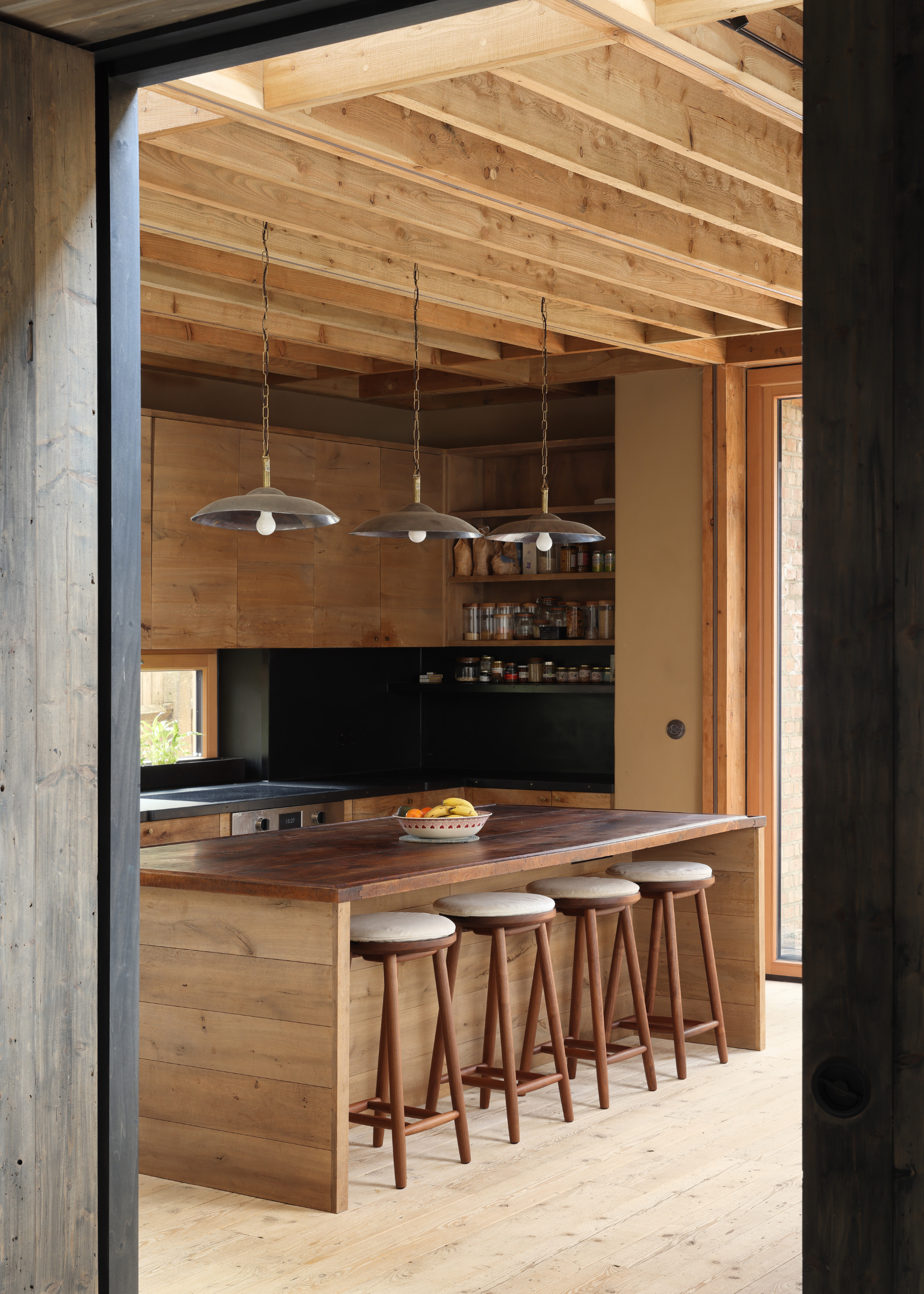 all wooden kitchen with three pendant lights over the island