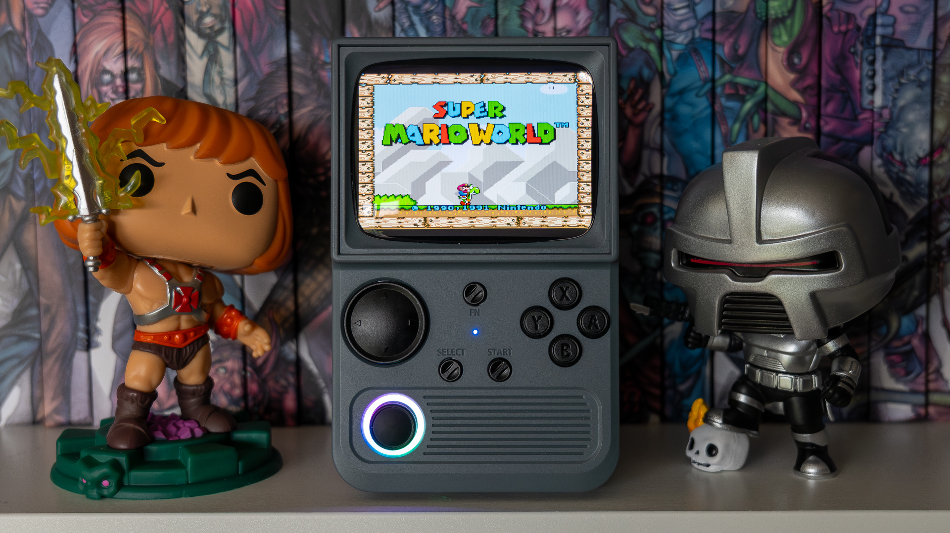 R36T Retro TV Handheld on a shelf in front of 2000AD books and flanked by Funko Pops
