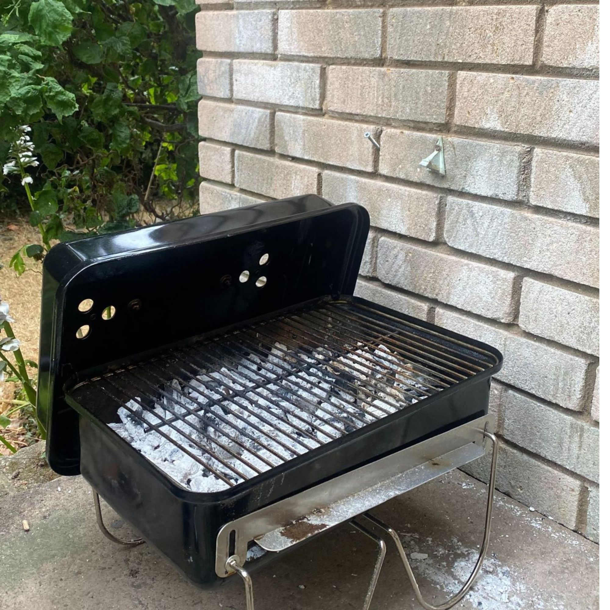 Weber BBQ in black on terrace, lit