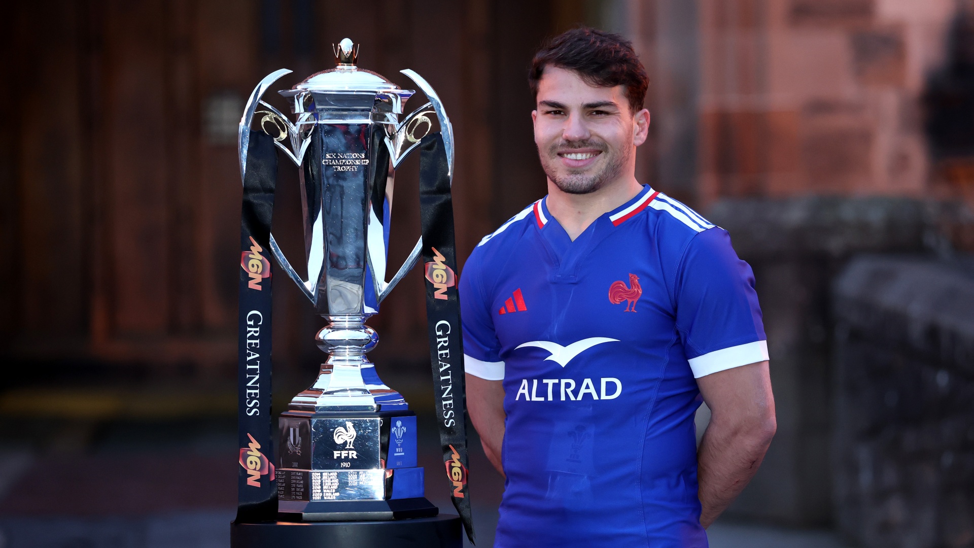 France captain Antoine Dupont standing with the Six Nations trophy