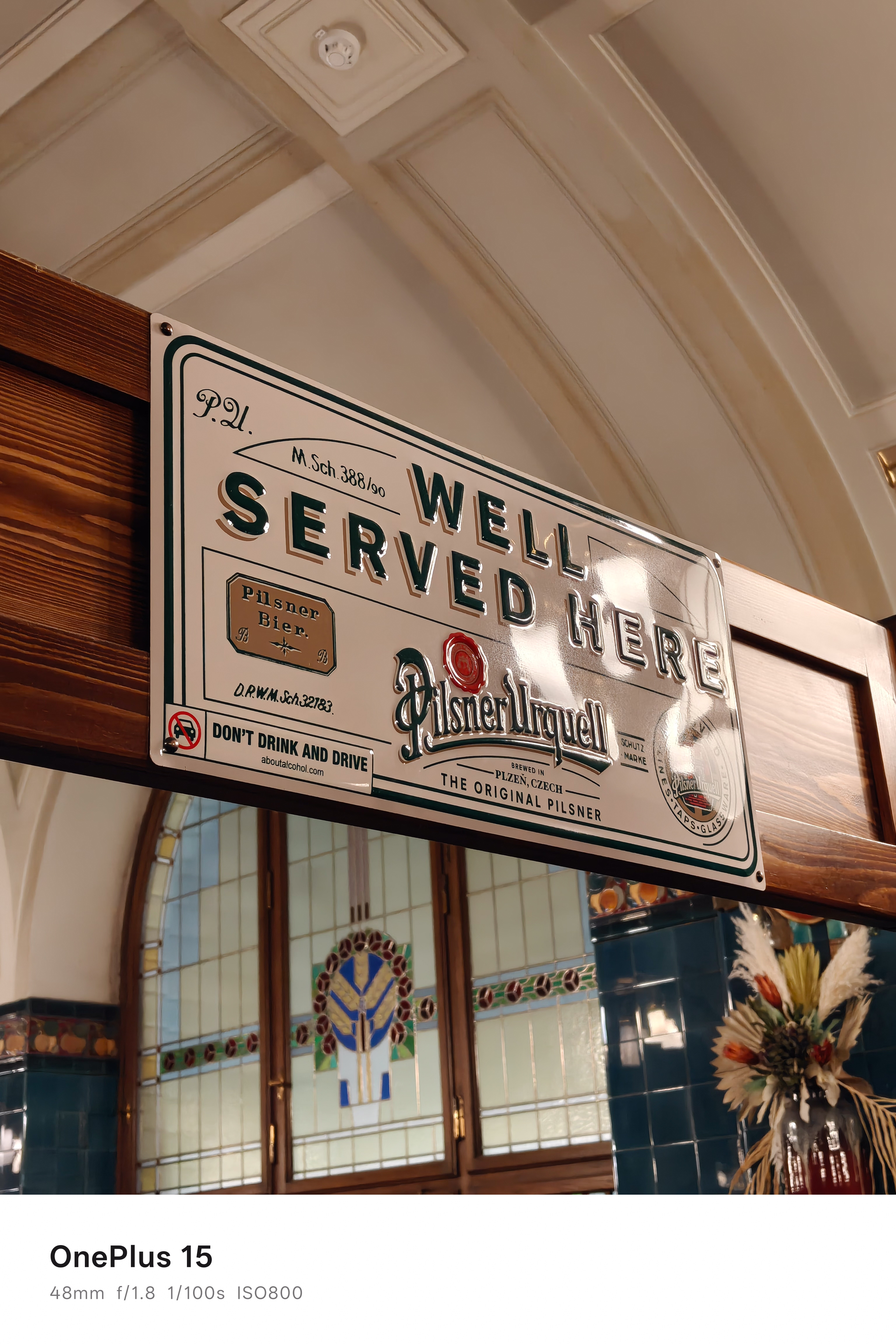 A sign in a beer hall advertising beer and reading "well served here"