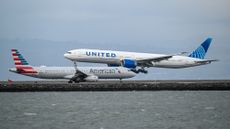 An American Airlines plane passes a landing United Airlines plane at San Francisco International Airport.
