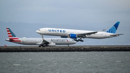 An American Airlines plane passes a landing United Airlines plane at San Francisco International Airport.