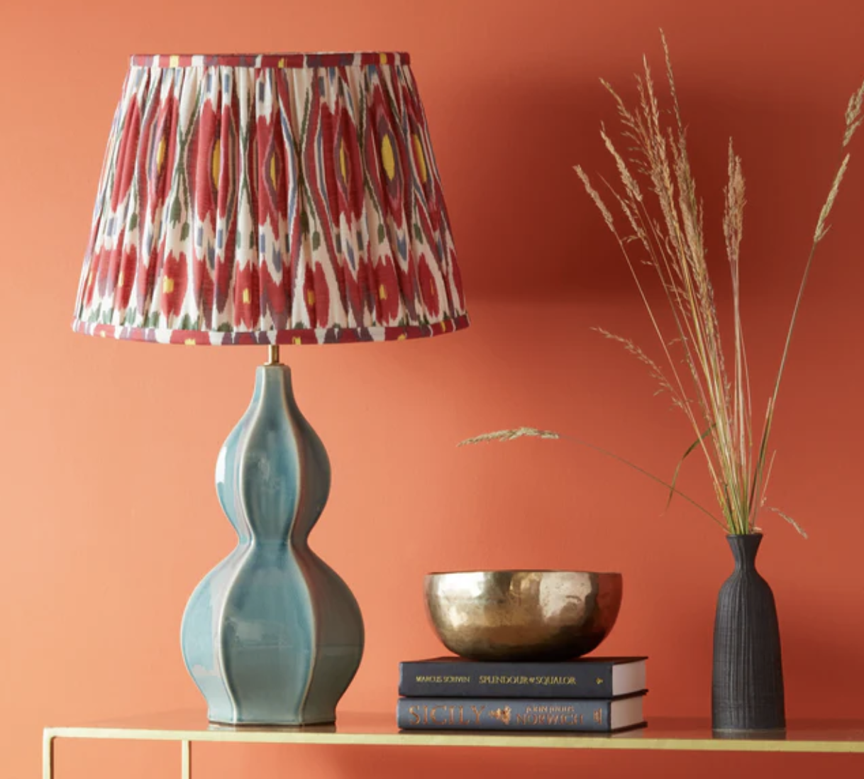 table lamp with a red patterned shade against a bright wall