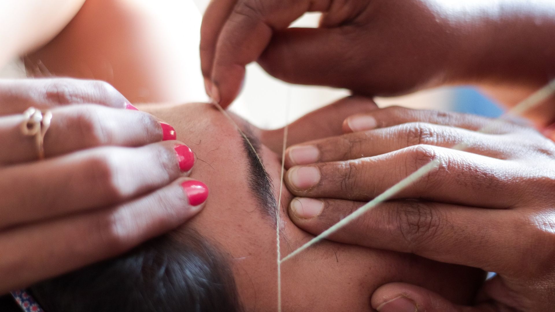 woman getting her eyebrows threaded