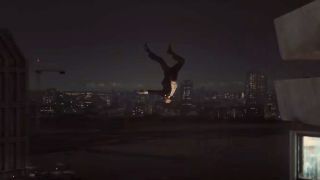 A man falls from the side of a skyscraper at night in High-Rise