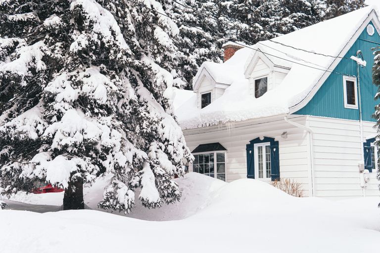 在雪遭受冻管的雪的房子