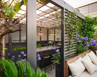 zoned seating areas under a pergola in a backyard