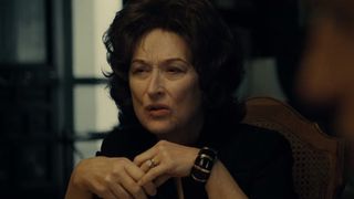 Meryl Streep, with poofy black hair, sits at her family dinner table in August: Osage County