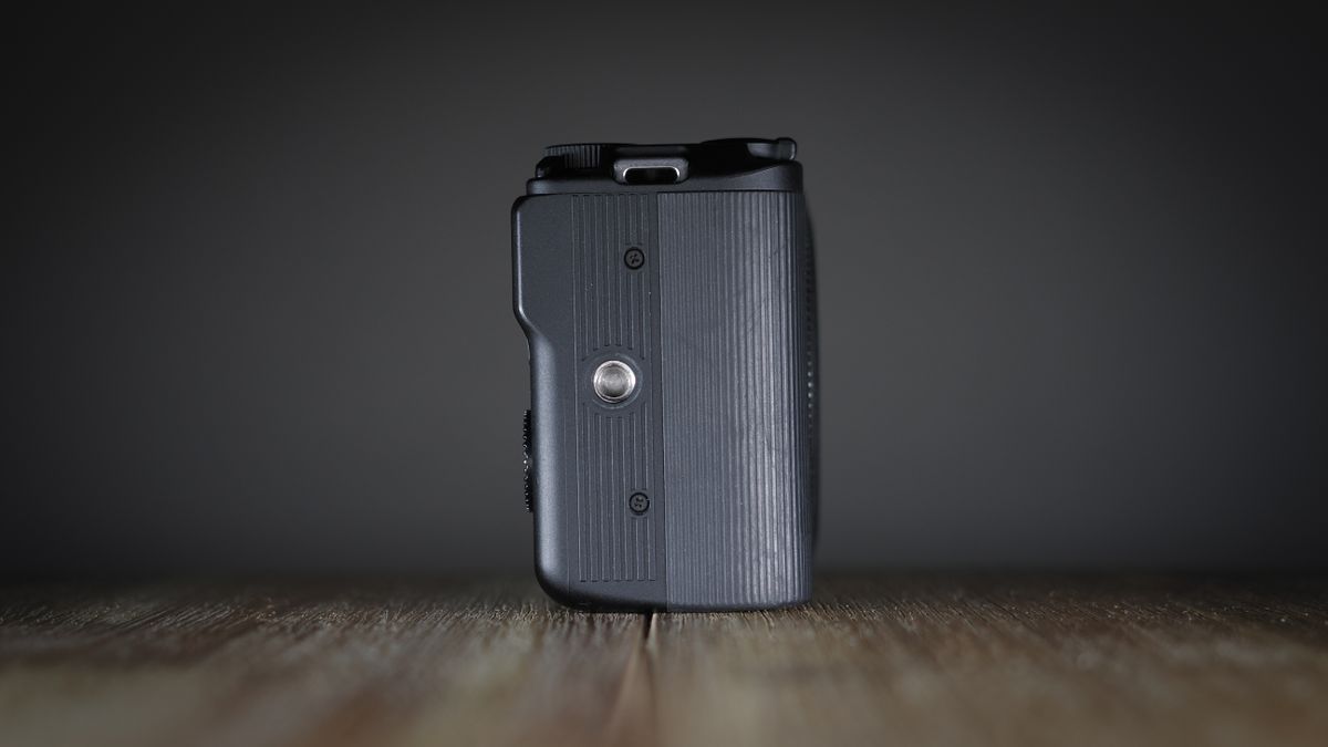 Canon EOS R50 V on a wooden surface, against a dark background