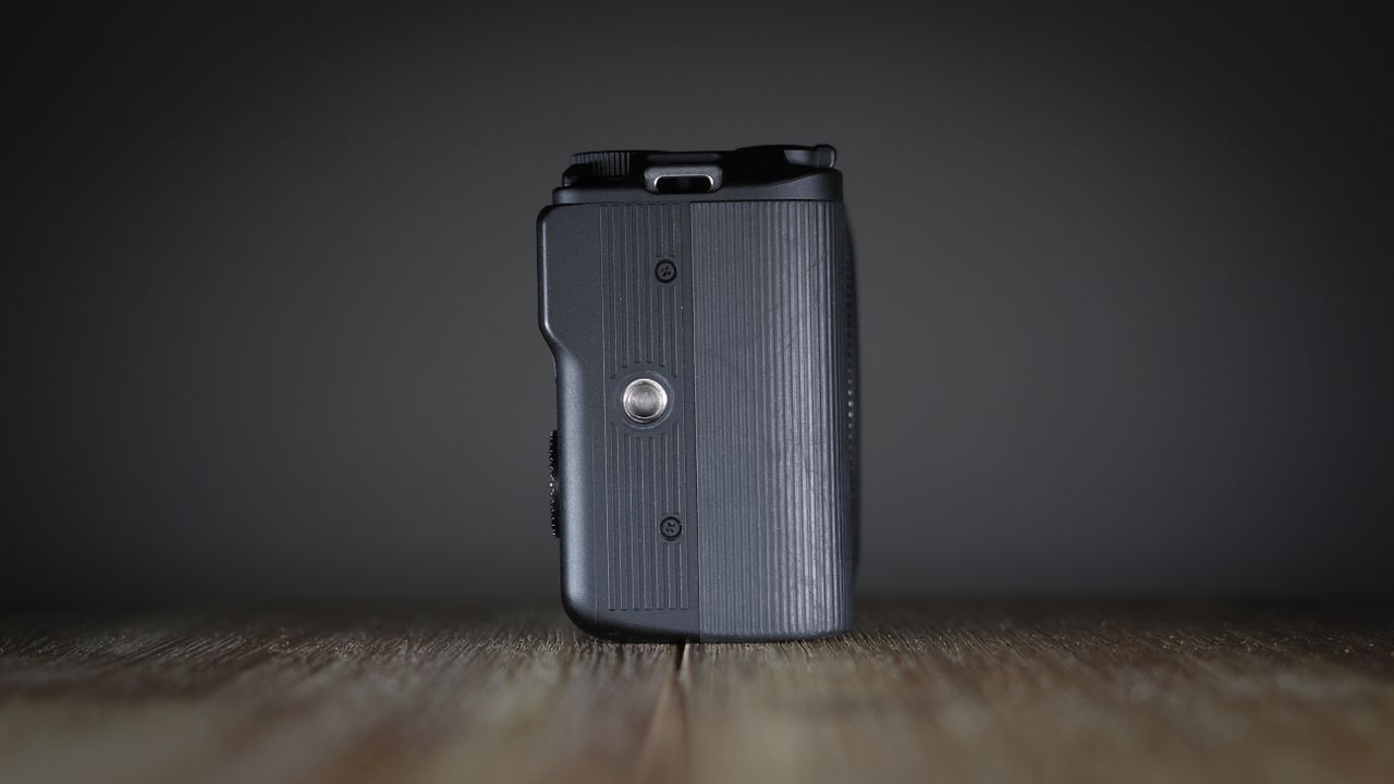 Canon EOS R50 V on a wooden surface, against a dark background